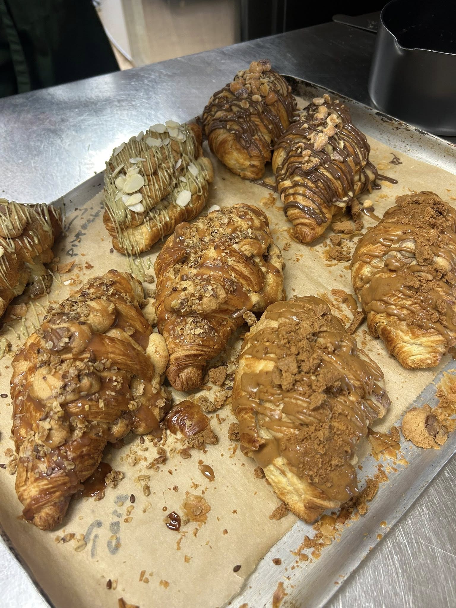 Freshly baked croissants loaded with caramel, chocolate and almond toppings